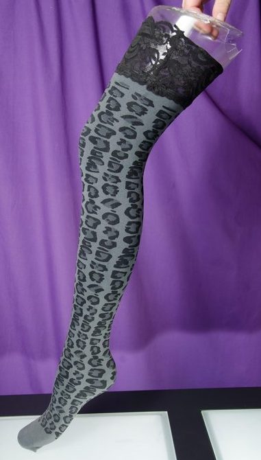 Thigh high black patterned compression hose on a mannequin. 